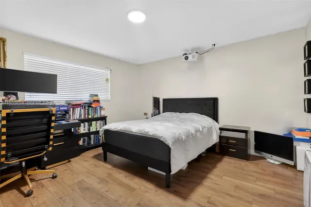 a bedroom with a bed and a flat tv screen on wall