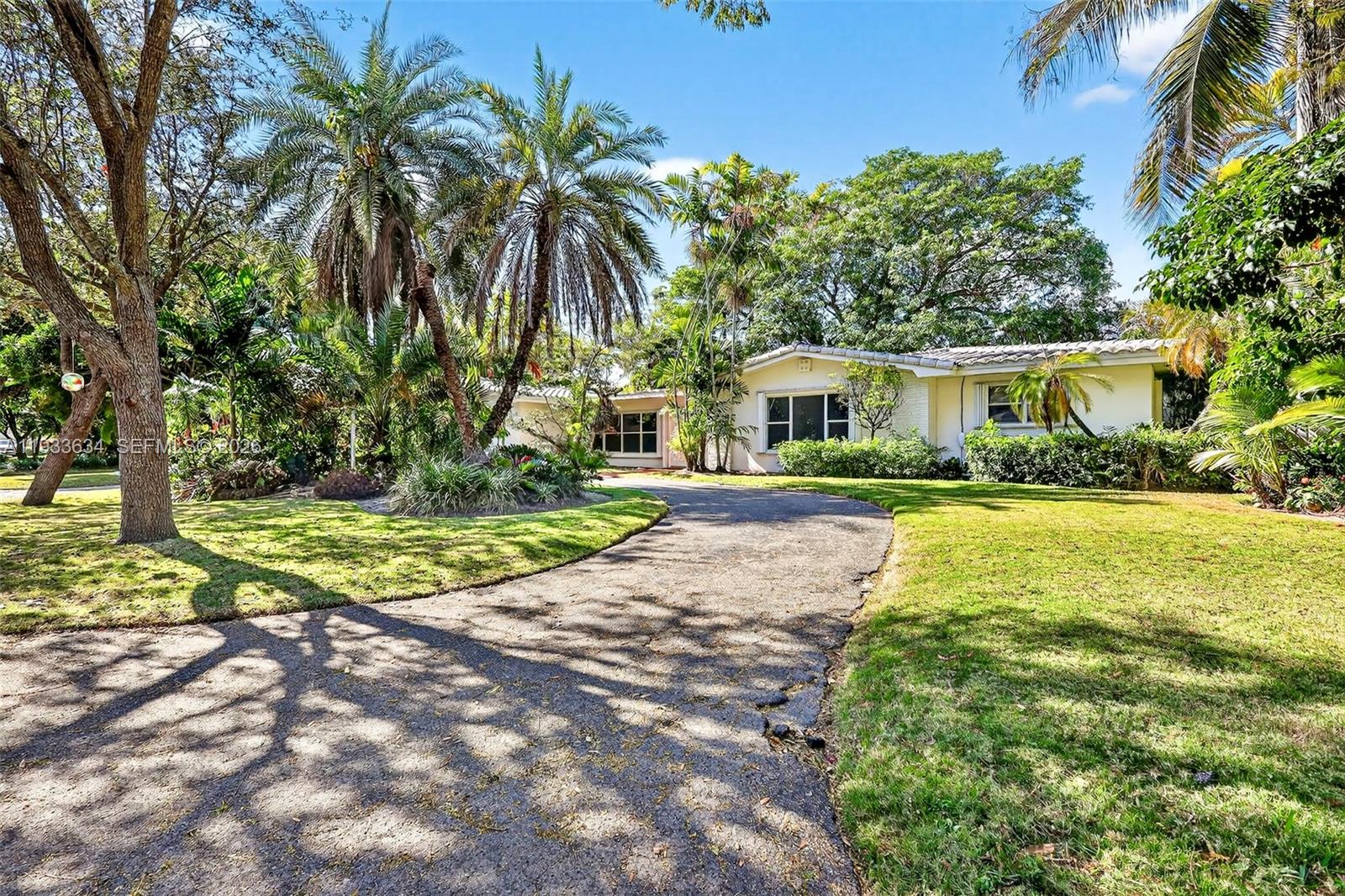 11890 Southwest 72nd Place Pinecrest, FL 33156 - Photo 3 of 39 a view of house with swimming pool and tall trees