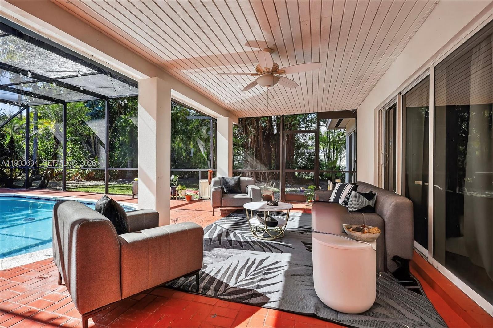 11890 Southwest 72nd Place Pinecrest, FL 33156 - Photo 33 of 39 a living room with furniture and large windows
