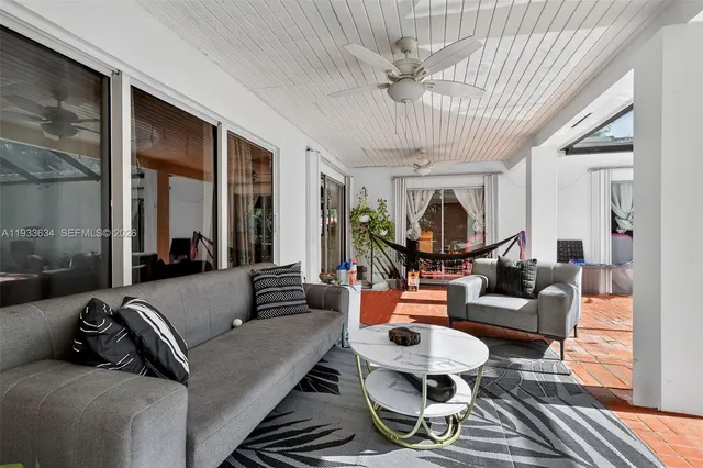 a living room with furniture a chandelier and a large window