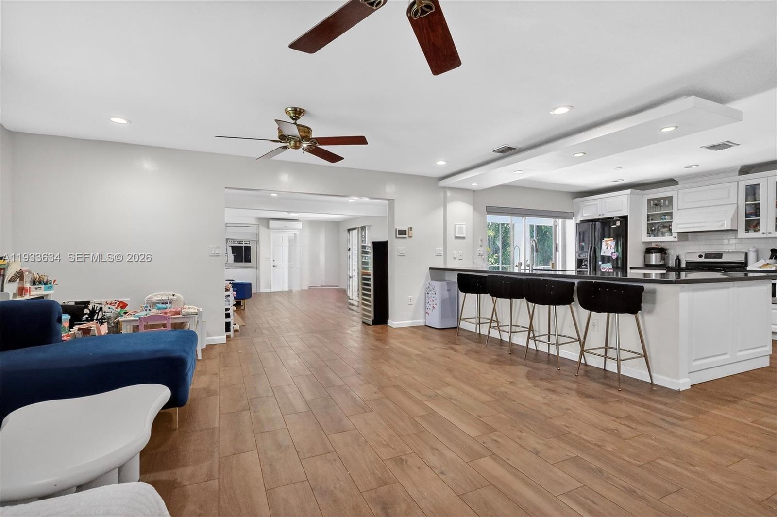 11890 Southwest 72nd Place Pinecrest, FL 33156 - Photo 9 of 39 a living room with furniture and kitchen view