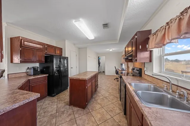 a kitchen with stainless steel appliances granite countertop a sink a stove and a refrigerator