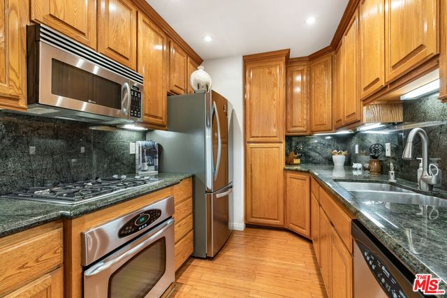 a kitchen with stainless steel appliances granite countertop a stove a microwave and a sink