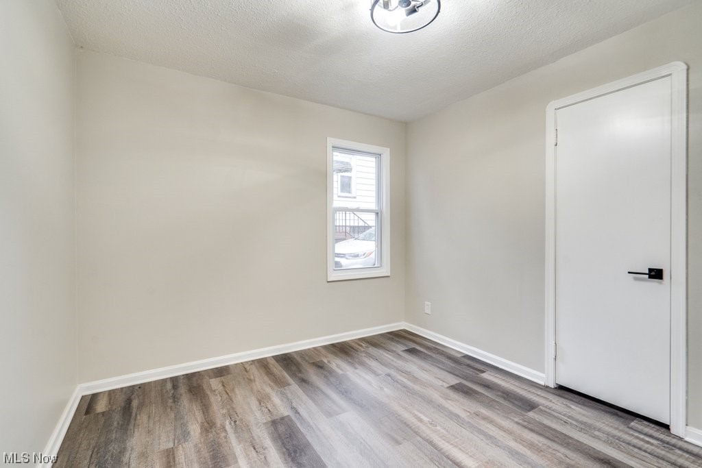 1596 Sheffield Road Cleveland, OH 44121 - Photo 18 of 35 Spare room with light hardwood / wood-style flooring and a textured ceiling