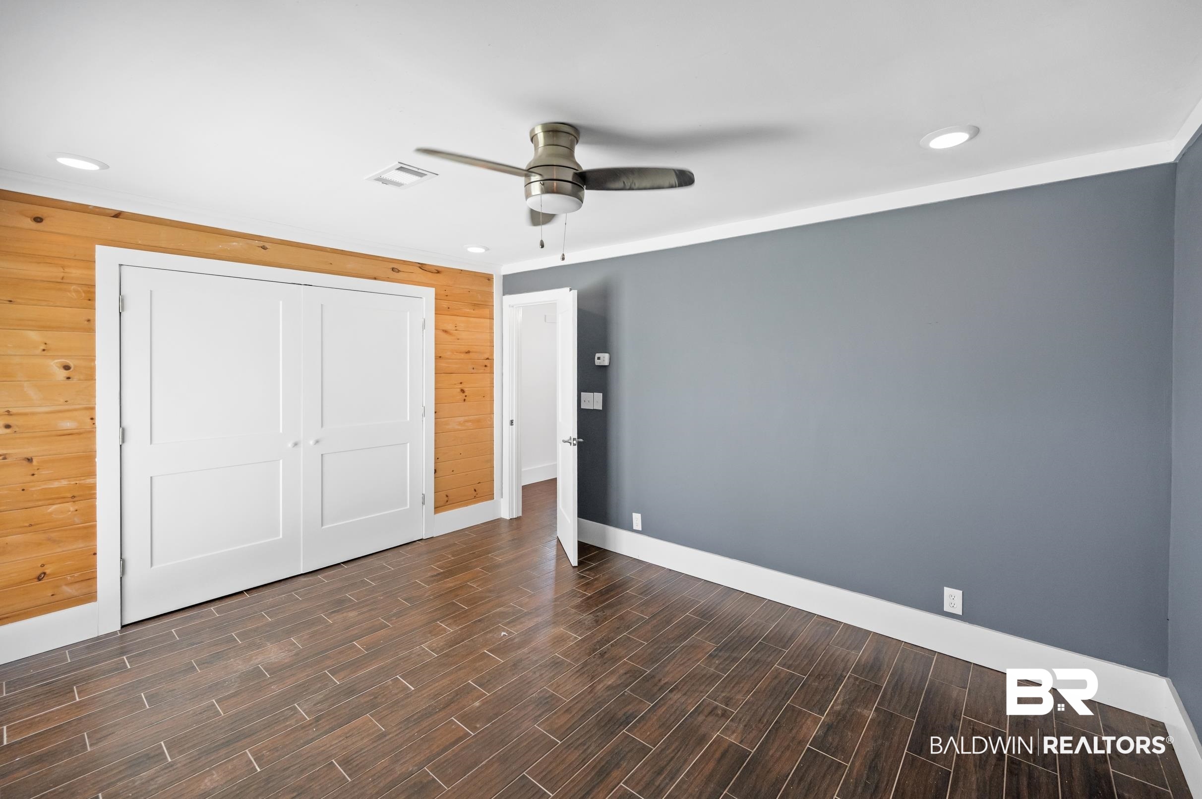 24663 Chestnut Street Elberta, AL 36530 - Photo 12 of 22 Room featuring wood-finish plank tile flooring and a ceiling fan with integrated lighting