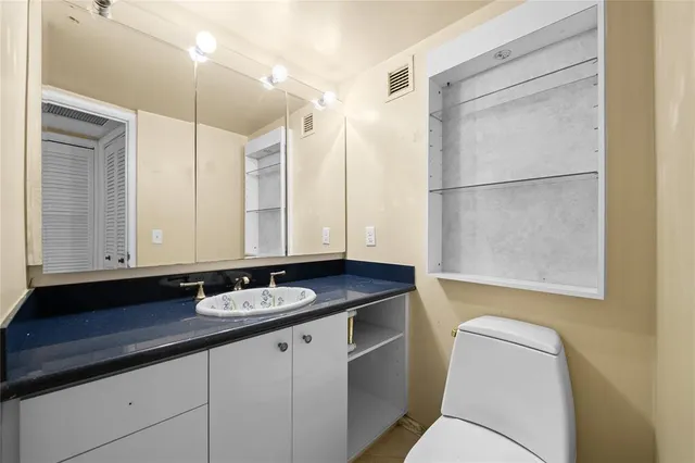 a spacious bedroom with a bed a couch and a large window