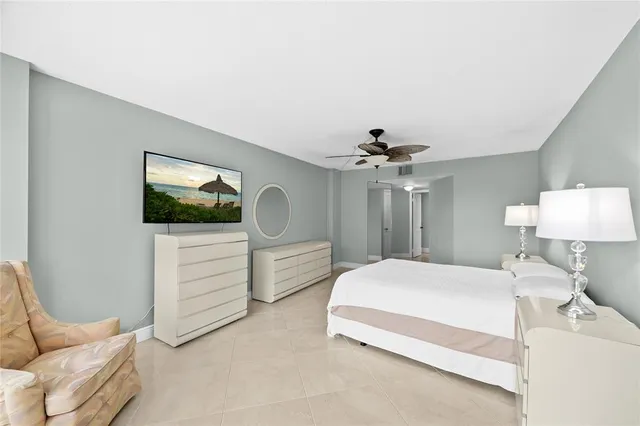 a bedroom with a large bed and a chandelier