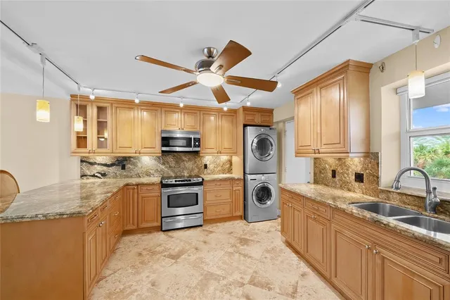 a large kitchen with stainless steel appliances granite countertop a refrigerator and a sink