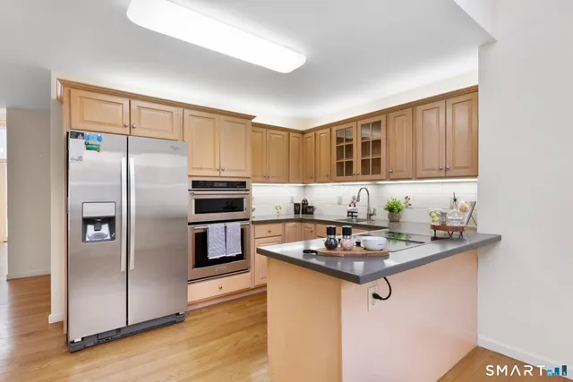 a kitchen with kitchen island a counter top space cabinets and stainless steel appliances