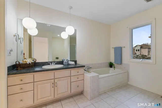a bathroom with a granite countertop sink mirror and bathtub