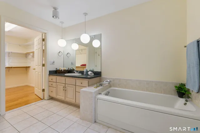 a bathroom with a bathtub sink and mirror