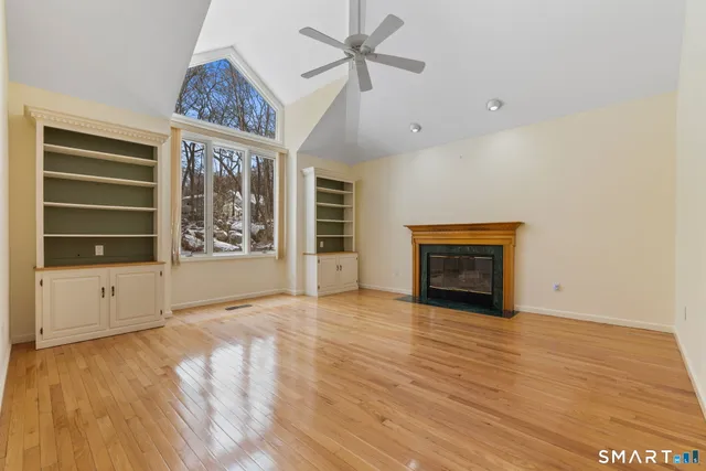 wooden floor fireplace and windows in an empty room
