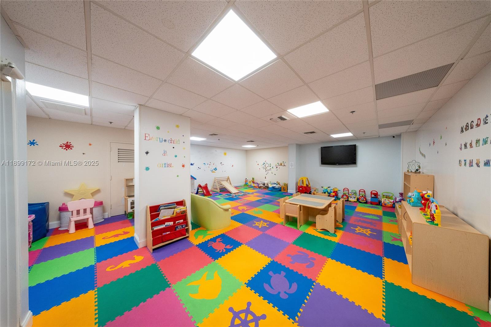 540 Brickell Key Drive, Unit 202 Miami, FL 33131 - Photo 11 of 60 a room with lots of baby toys and flat screen tv