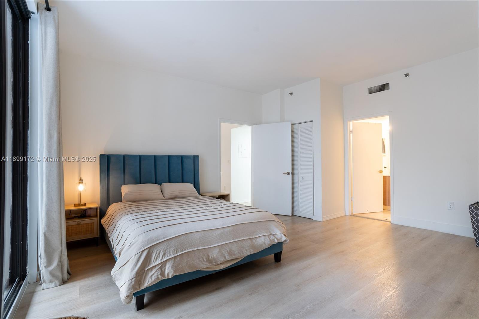 540 Brickell Key Drive, Unit 202 Miami, FL 33131 - Photo 38 of 60 a bedroom with a bed and a closet with wooden floor