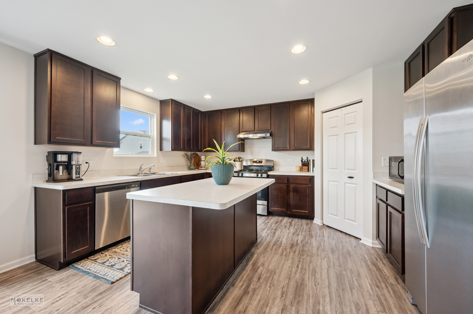 1024 Daniel Street Plano, IL 60545 - Photo 11 of 27 a kitchen with kitchen island granite countertop wooden floors stainless steel appliances a sink and a counter