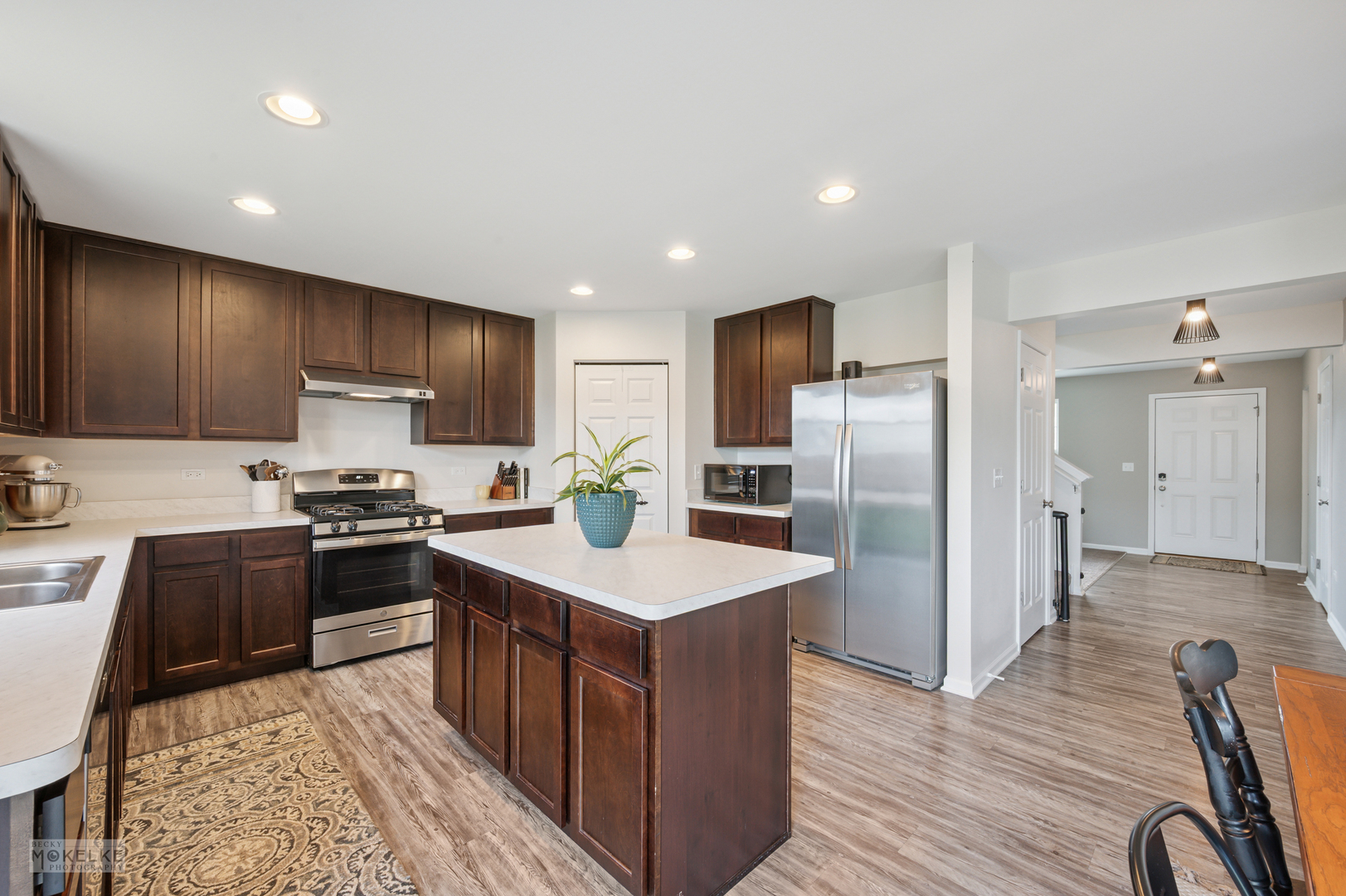 1024 Daniel Street Plano, IL 60545 - Photo 12 of 27 a kitchen with stainless steel appliances granite countertop a stove top oven a refrigerator and a sink with wooden floor