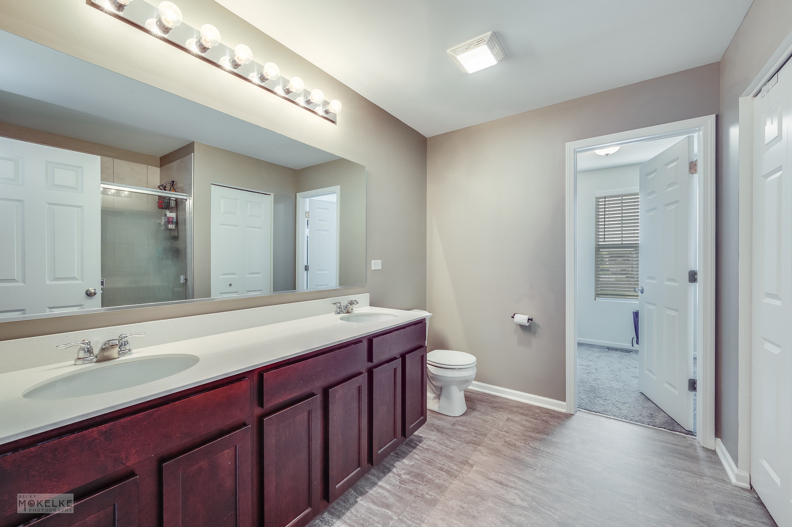 1024 Daniel Street Plano, IL 60545 - Photo 25 of 27 a spacious bathroom with a granite countertop sink and a mirror
