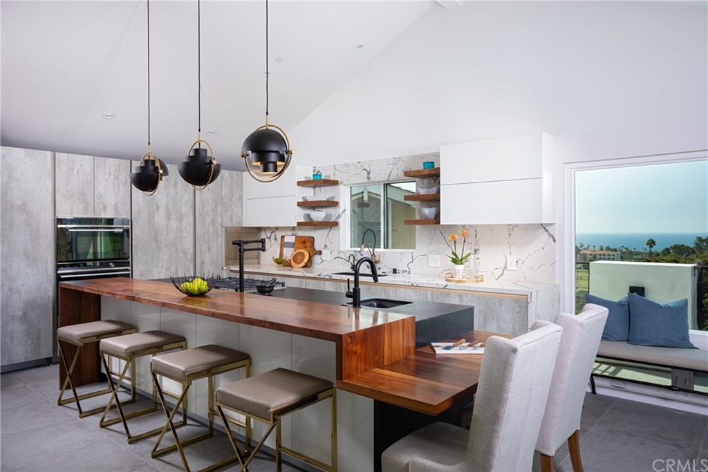 447 Avenida Crespi San Clemente, CA 92672 - Photo 15 of 42 a kitchen with stainless steel appliances kitchen island granite countertop a table and chairs in it