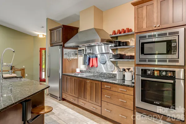 a kitchen with stainless steel appliances granite countertop a stove and cabinets