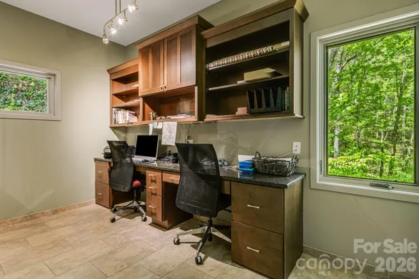 a view of a workspace with furniture and a window