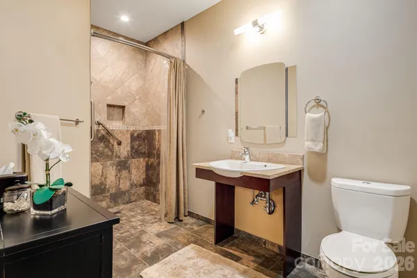 a bathroom with a sink a toilet and shower
