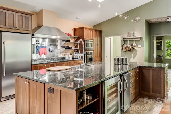 a kitchen with stainless steel appliances granite countertop a sink and a refrigerator