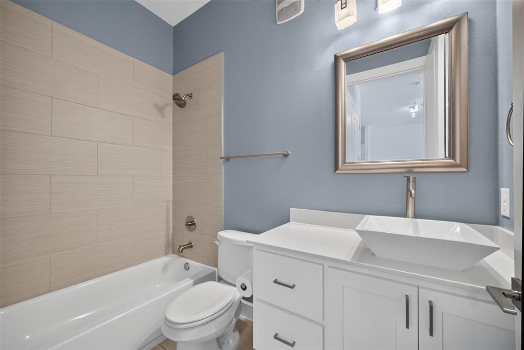 5015 Meridian Lane, Unit 2102 Addison, TX 75001 - Photo 25 of 36 Modern bathroom featuring a freestanding vanity with a vessel sink, a brushed nickel framed mirror, white subway tile shower surround, and a tub/shower combination