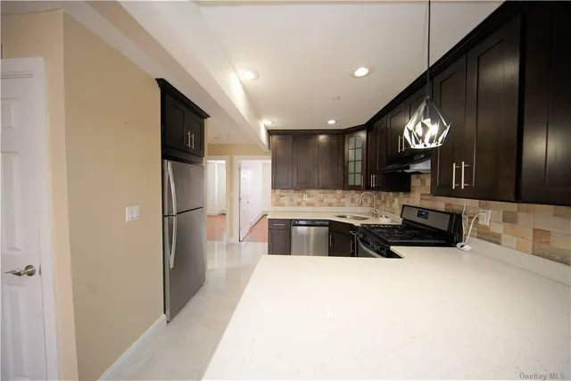 a large kitchen with a sink and a refrigerator
