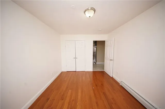 a view of a room with wooden floor and a window