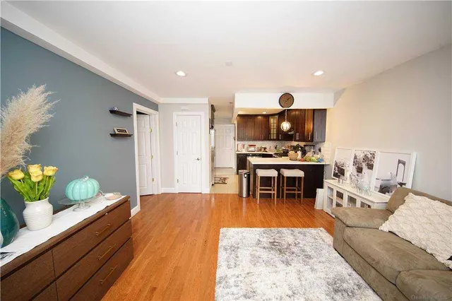 a living room with furniture and a dining table with wooden floor