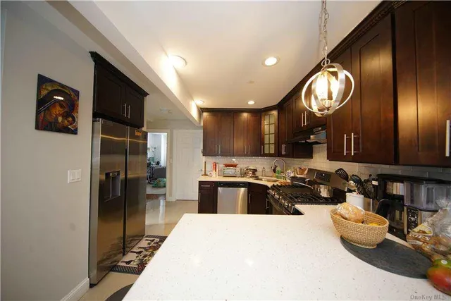 a kitchen with stainless steel appliances granite countertop a sink dishwasher stove and refrigerator