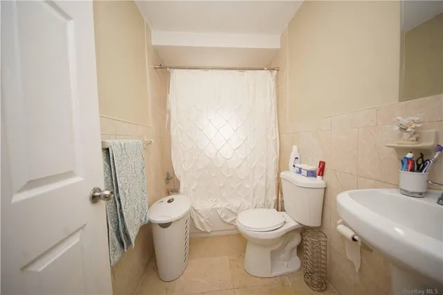 a white toilet sitting next to a bathroom sink and a shower