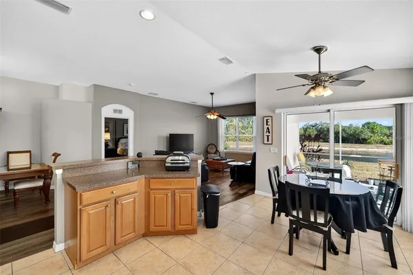 a large kitchen with kitchen island a stove a sink dishwasher a dining table and chairs with wooden floor