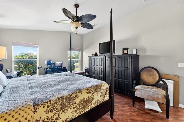 a bedroom with a bed a large window and painting on the wall