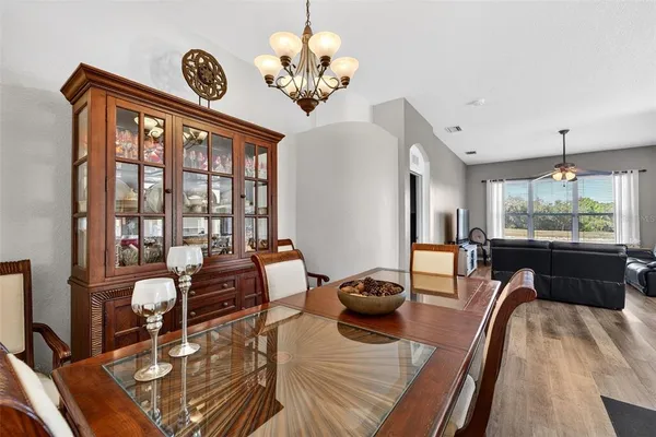 a view of a dining room with furniture a chandelier and wooden floor