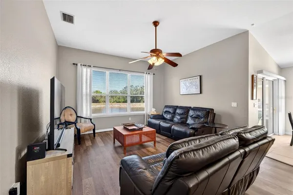 a living room with furniture a flat screen tv and a window