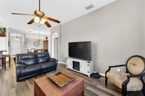a living room with couch kitchen view and a window