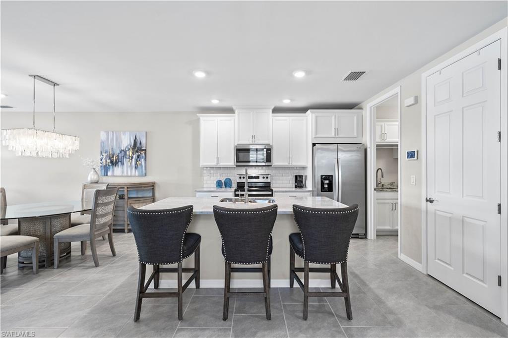14558 Edgewater Circle Naples, FL 34114 - Photo 6 of 40 a kitchen with refrigerator and table
