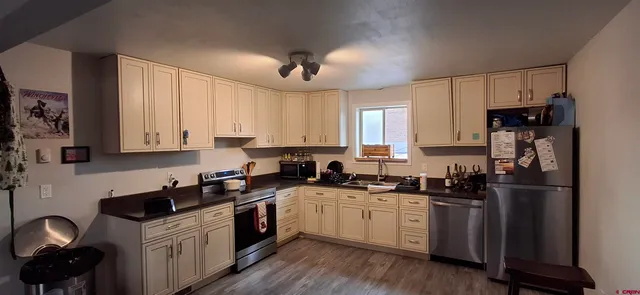 a kitchen with a sink white cabinets and black appliances