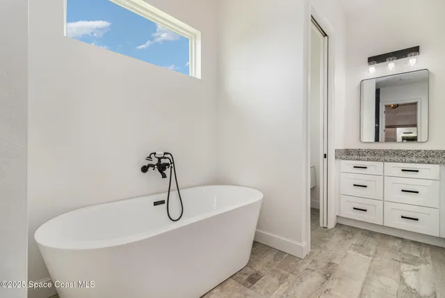 a bathroom with a sink a bathtub and a mirror