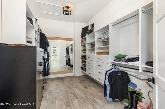 a view of walk in closet with clothes and shoes