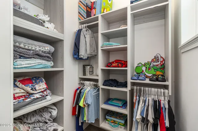 a view of walk in closet with clothes and shoes