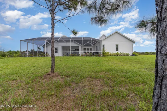 a view of a big building with a big yard and large trees