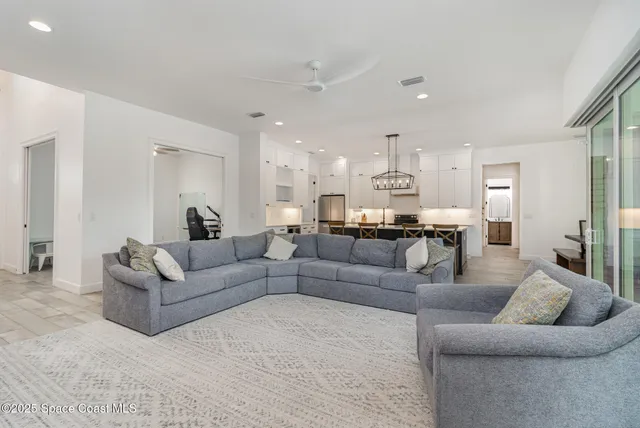 a living room with furniture and kitchen view