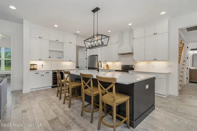 a kitchen with stainless steel appliances granite countertop a table chairs sink refrigerator and microwave
