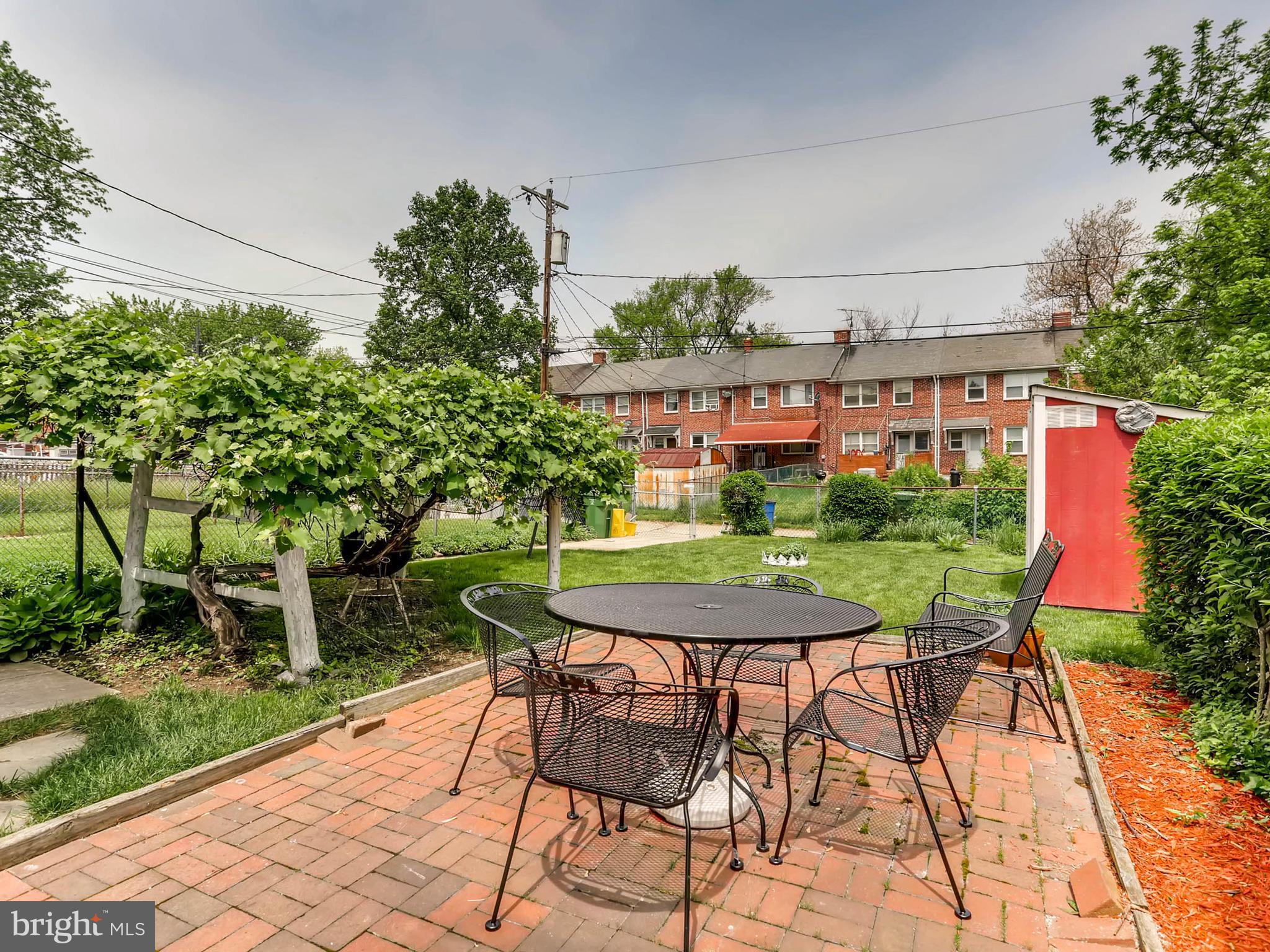 1316 Silverthorne Road Baltimore, MD 21239 - Photo 22 of 27 a table and chairs in front of a house