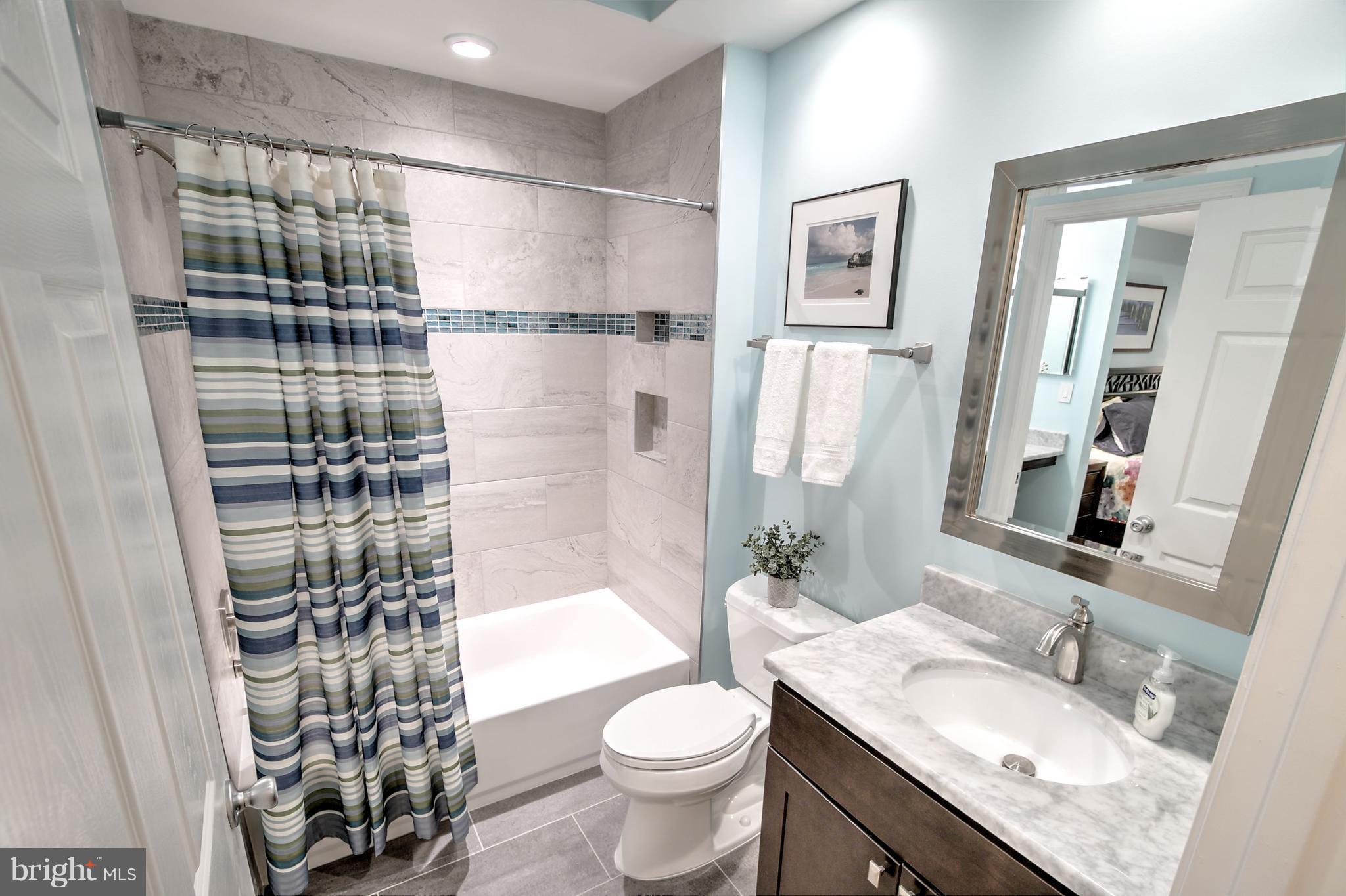 11315 Sundial Court, Unit 212 Reston, VA 20194 - Photo 12 of 18 a bathroom with a granite countertop sink toilet and shower