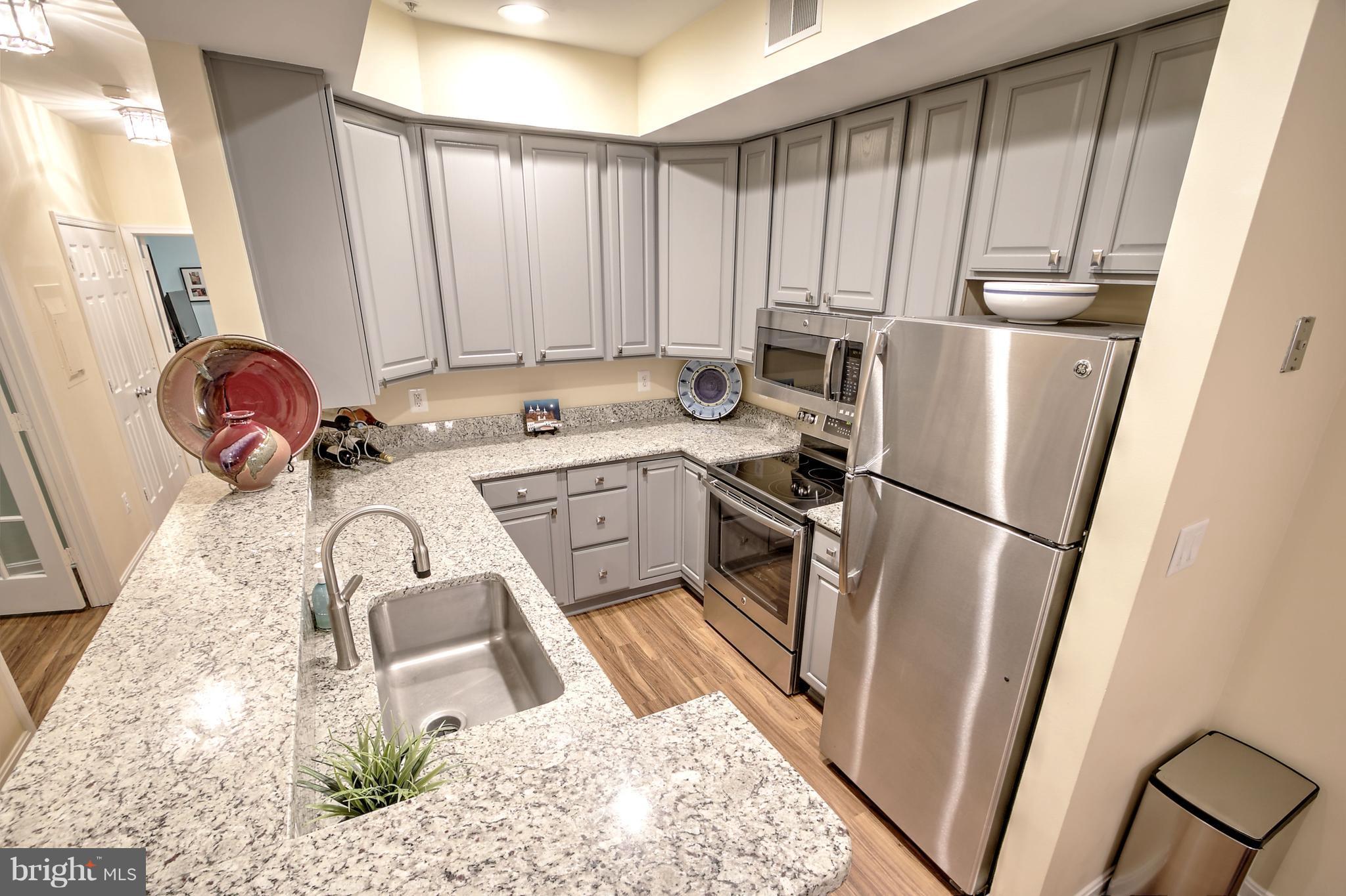 11315 Sundial Court, Unit 212 Reston, VA 20194 - Photo 8 of 18 a kitchen with a refrigerator a sink and a stove