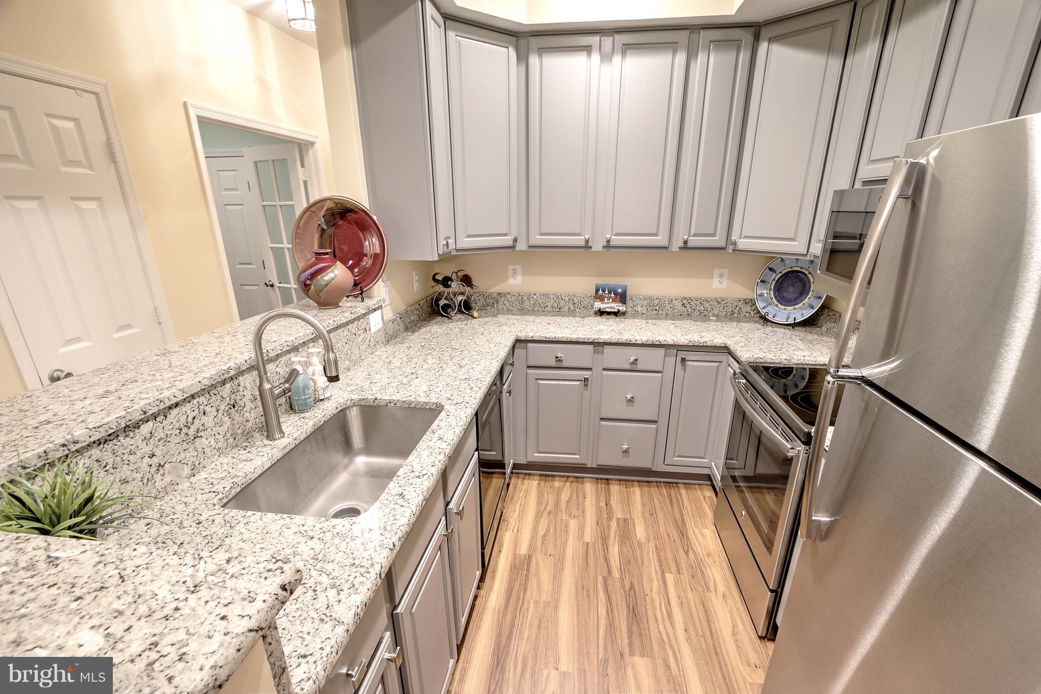 11315 Sundial Court, Unit 212 Reston, VA 20194 - Photo 9 of 18 a kitchen with a sink a refrigerator a stove a washer and dryer