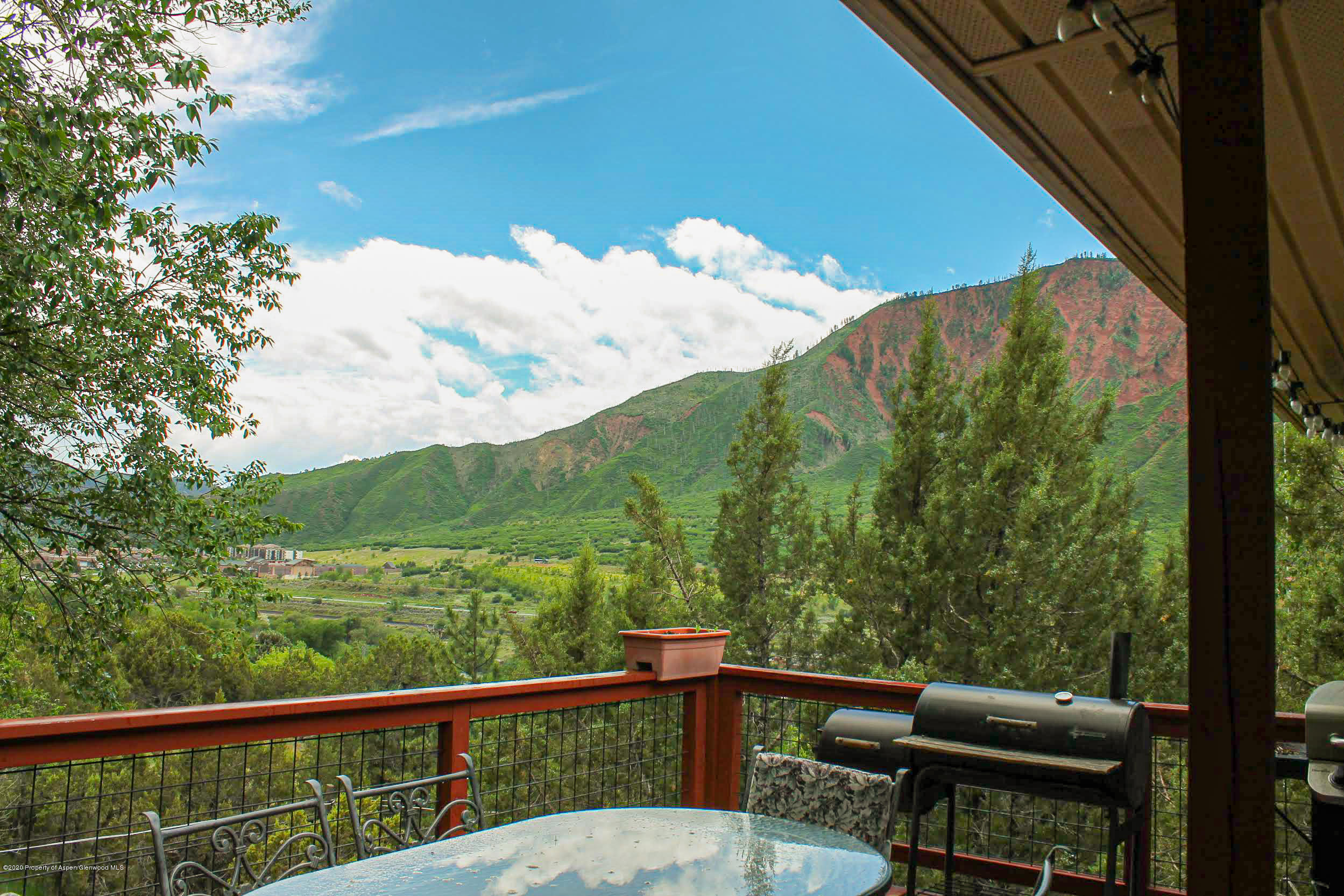 a view of a balcony with mountain view and a garden